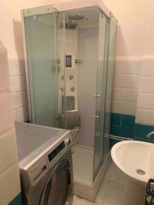 uma casa de banho com um chuveiro e uma máquina de lavar roupa em Appartement 5 lits climatisé salon 2chambres cuisine équipée SDB em Staoueli