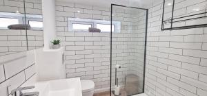 a bathroom with a toilet and a glass shower at The Beach House in Kent
