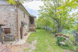 un patio vacío junto a un antiguo edificio de piedra en La fonte di Gaiche, en Collebaldo