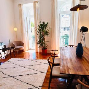 sala de estar con mesa de madera y ventana grande en Royal Prince Apartments - Jardim do Príncipe Real, en Lisboa