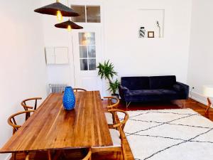 una mesa de madera en una sala de estar con sofá en Royal Prince Apartments - Jardim do Príncipe Real, en Lisboa