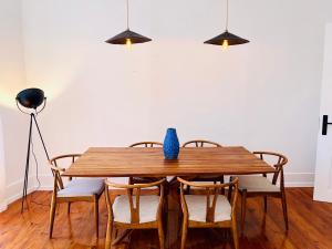 una mesa de comedor con sillas y un jarrón azul. en Royal Prince Apartments - Jardim do Príncipe Real, en Lisboa