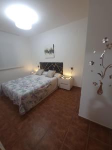a bedroom with a bed and a table with a lamp at Chalet Edy con piscina in Peñíscola