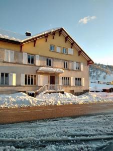 a large building with snow in front of it at Cocon lumineux près des pistes in La Bresse