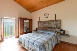 a bedroom with a bed and a large window at La fonte di Gaiche in Collebaldo