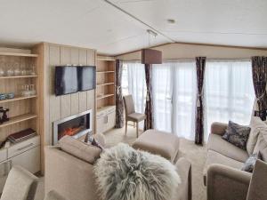 a living room with a couch and a fireplace at Holiday home Tansøy in Tansøy