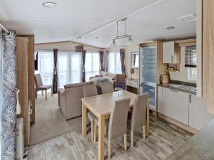 Il comprend une cuisine et un salon avec une table et des chaises. dans l'établissement Holiday home Tansøy, à Tansøy