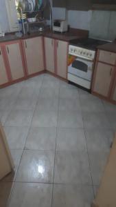 uma cozinha com fogão e piso em azulejo branco em Sandorini country club em Banī Salāmah
