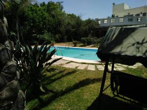 uma vista para uma piscina num quintal em Sandorini country club em Banī Salāmah