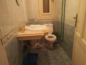 uma casa de banho com um lavatório e um WC em Sandorini country club em Banī Salāmah