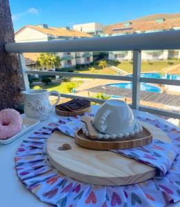 einen Tisch mit einem Hut und einem Teller mit Lebensmitteln in der Unterkunft Flat E311 - Aldeia das águas in Barra do Piraí