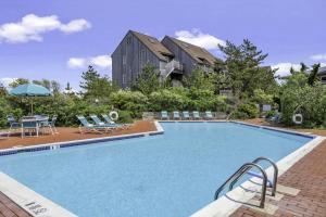 a large swimming pool with chairs and a house at Unit 1723 Ocean Colony Beach in Amagansett