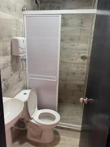 a bathroom with a toilet and a sink at Hotel Gloria Del Norte in Cartagena de Indias