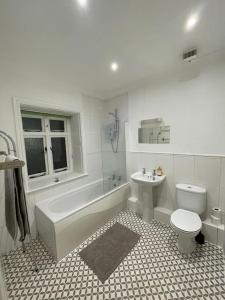 a bathroom with a tub and a toilet and a sink at Fully Equipped Queen Anne Court with FREE PARKING By Prescott Apartments in Abingdon