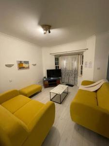 a living room with a yellow couch and a table at Fully Furnished Queen Anne Court with FREE PARKING By Prescott Apartments in Abingdon