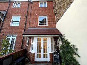 a red brick house with a white door at Modern Queen Anne Court with FREE PARKING By Prescott Apartments in Abingdon