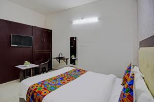 a hotel room with a bed with a colorful blanket at Shree Hotel in Lucknow