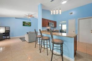 a kitchen and living room with a bar with stools at Luxury Villa in Orlando with Pool - 10 min Disney in Orlando