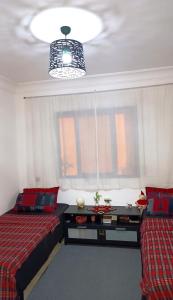 1 Schlafzimmer mit 2 Betten, einem Fenster und einem Kronleuchter in der Unterkunft Dar Shama - Women only in Rabat