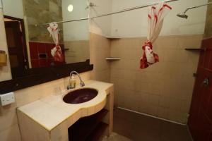 a bathroom with a sink and a shower and a mirror at Serenity Eco Guesthouse - CHSE certified in Canggu