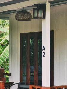 a house with a door and a sign on it at Nakhokyor Farm in Ko Yao Yai