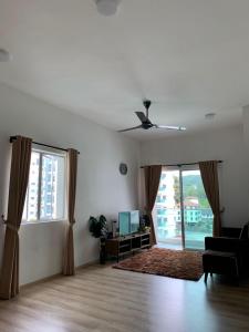 sala de estar con sofá y ventilador de techo en Aira Muslim's Homestay, en Tanah Rata