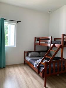 a bedroom with two bunk beds and a window at Aira Muslim's Homestay in Tanah Rata