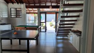 una cucina con tavolo da ping pong e scala di Lindo Sobrado com Piscina em Condomínio Fechado a Bertioga