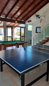 tavolo da ping pong in una stanza con due tavoli di Lindo Sobrado com Piscina em Condomínio Fechado a Bertioga
