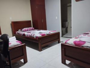 two beds in a room with pink pillows on them at HOTEL MARACANA in Bucaramanga