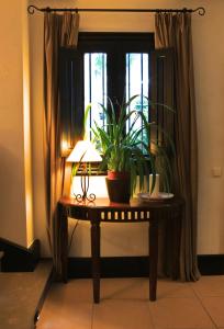 a table with a lamp and a plant in a window at Santuario San José in San José