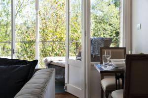 sala de estar con sofá, mesa y ventanas en Provence Spa Villa 1 en Hepburn Springs