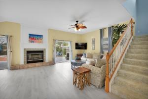 a living room with a staircase and a fireplace at Heated Pool Pet Friendly Home in Jacksonville Beach
