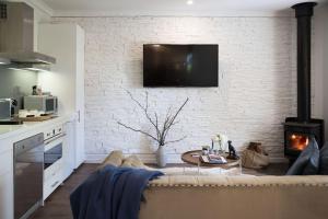 sala de estar con sofá y pared de ladrillo en Provence Spa Villa 1 en Hepburn Springs