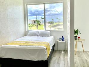 a bed in a room with a large window at abundance okinawa in Kouri