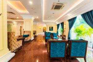un soggiorno con sedie blu e una grande finestra di Tran Vien Dong Hotel a Nha Trang