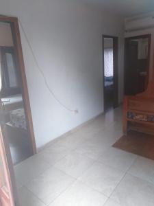 a room with a white wall and a tiled floor at Toquilla Hotel in Cojimíes