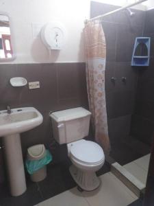 a bathroom with a toilet and a sink and a shower at Toquilla Hotel in Cojimíes