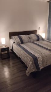 a bedroom with a large bed with two lamps on it at Departamento esmeralda Iquique x dia in Iquique