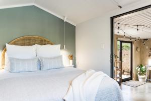 a bedroom with a large bed with white pillows at Flaxpod Cabin in Raglan