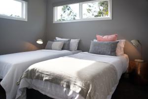 two beds in a room with two windows at Quartz Retreat in Daylesford