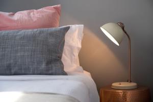 a bed with a pillow and a lamp on a table at Quartz Retreat in Daylesford