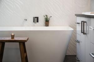 a white bath tub in a bathroom with a table at Quartz Retreat in Daylesford