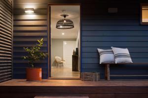 a blue house with a bench with pillows on it at Quartz Retreat in Daylesford