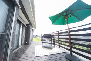 een groene paraplu op het balkon van een gebouw bij Awaji Riverside Terrace in Shizuki 780 in Shizuki