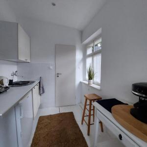 a white kitchen with a sink and a table at BIAŁY DOMEK w Puszczykowie in Puszczykowo