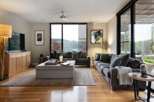 a living room with a couch and a tv at Ridge House in Hepburn Springs