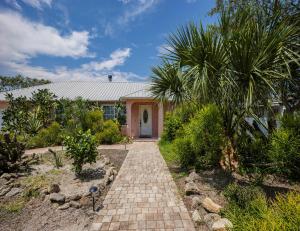 una casa con una pasarela de ladrillo que conduce a la puerta principal en Villa Ventura, en Butler Beach