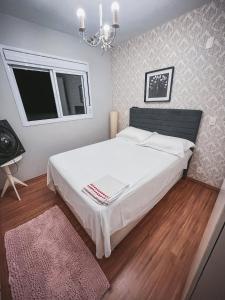 um quarto com uma grande cama branca e um lustre em Allianz Parque , Perdizes em São Paulo
