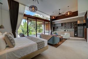 a bedroom with a large bed and a living room at The Studios Ubud in Ubud